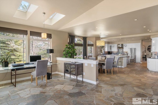 home office with vaulted ceiling with skylight