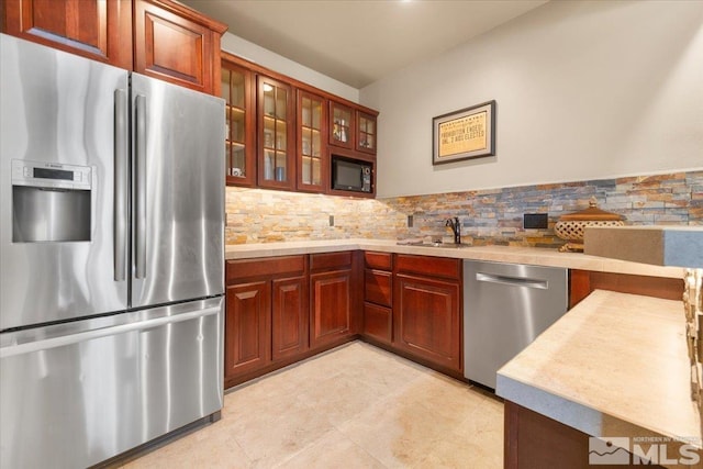 kitchen featuring backsplash, sink, and appliances with stainless steel finishes