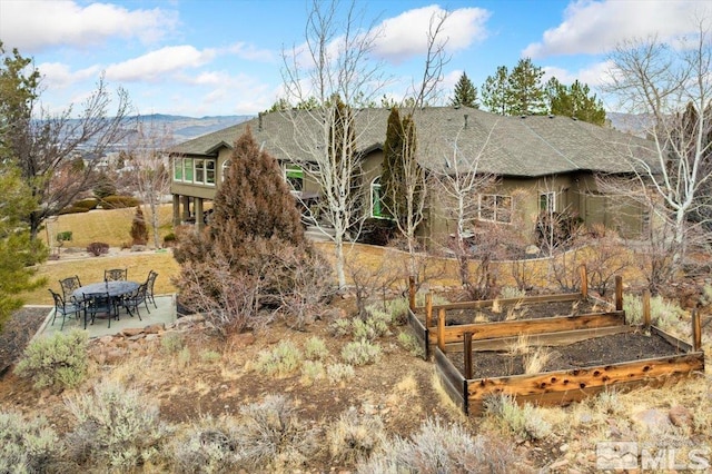 back of property featuring a mountain view and a patio