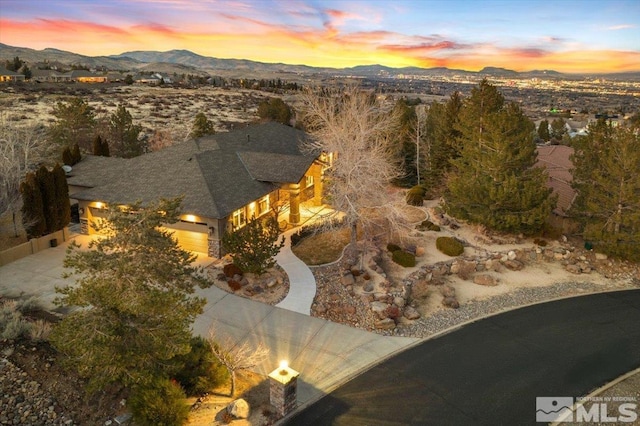 aerial view at dusk featuring a mountain view