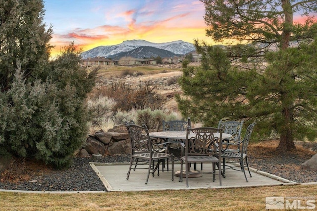 patio terrace at dusk featuring a mountain view