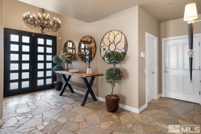 foyer with french doors and an inviting chandelier