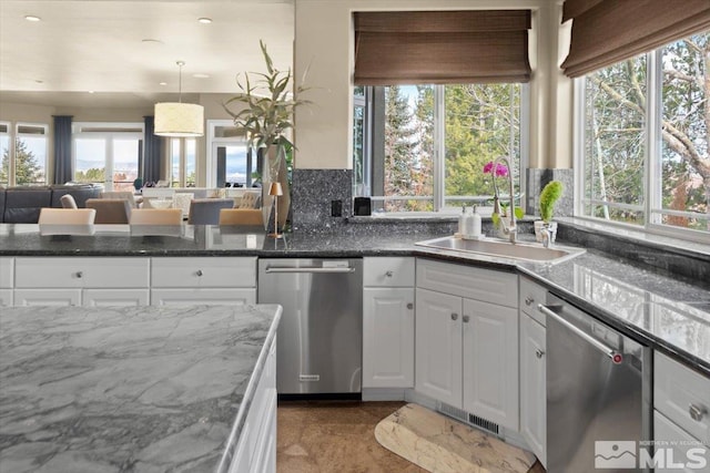 kitchen with dishwasher, white cabinets, pendant lighting, and sink