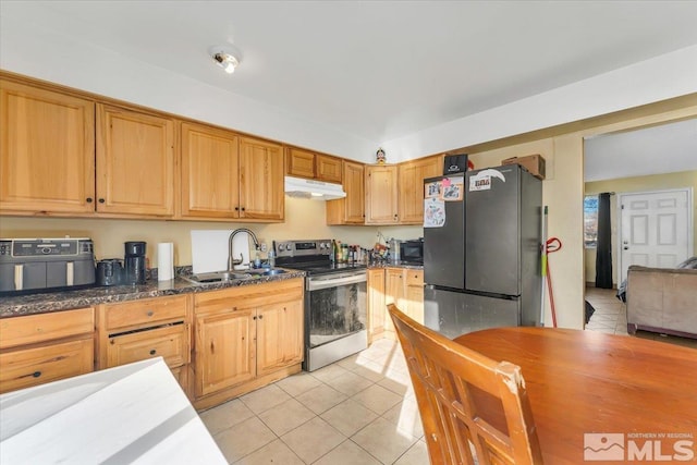 kitchen featuring light tile patterned floors, stainless steel appliances, dark stone countertops, and sink