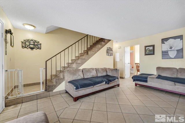 tiled living room featuring a textured ceiling