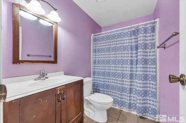 bathroom with toilet, vanity, tile patterned floors, and a shower with shower curtain