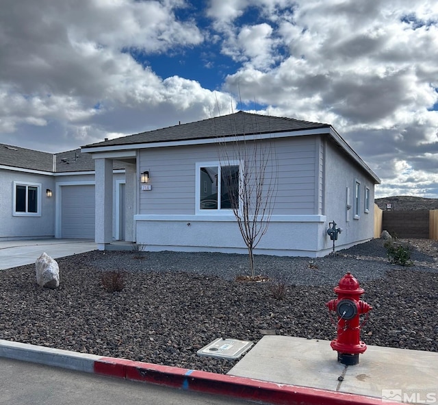 view of front of property featuring a garage, driveway, and fence