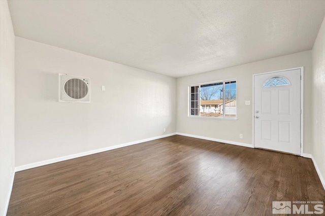 entrance foyer with dark wood-style floors, baseboards, and a textured ceiling