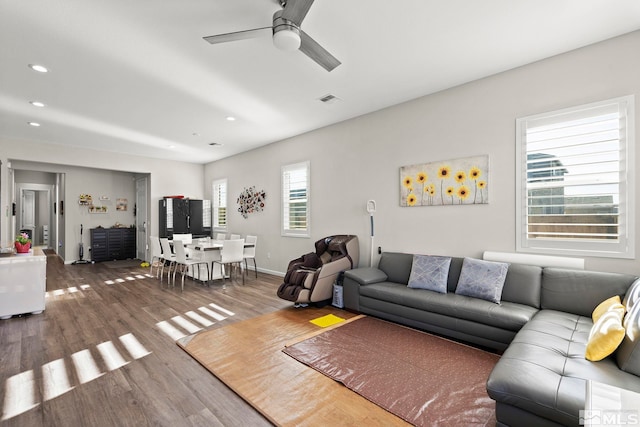 living room featuring ceiling fan and hardwood / wood-style flooring