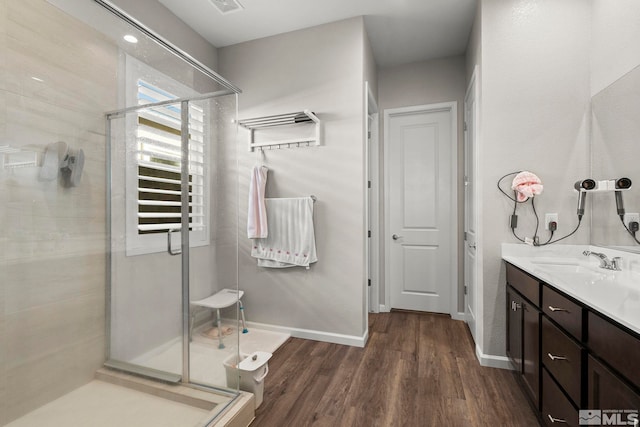 bathroom with hardwood / wood-style floors, vanity, and walk in shower