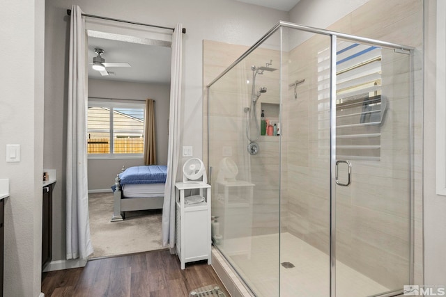 bathroom with walk in shower, wood-type flooring, vanity, and ceiling fan