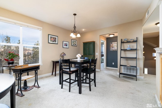 dining space with light carpet and a chandelier