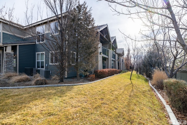 view of side of home with a lawn and cooling unit