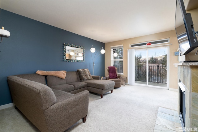 carpeted living room featuring a tile fireplace