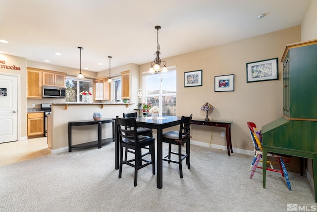 carpeted dining room featuring a chandelier