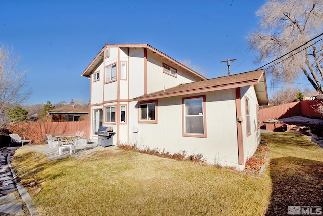 rear view of property featuring a yard and a patio area