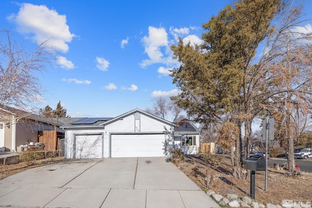 ranch-style house featuring a garage and solar panels