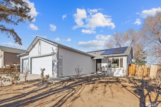 ranch-style house with solar panels and a garage