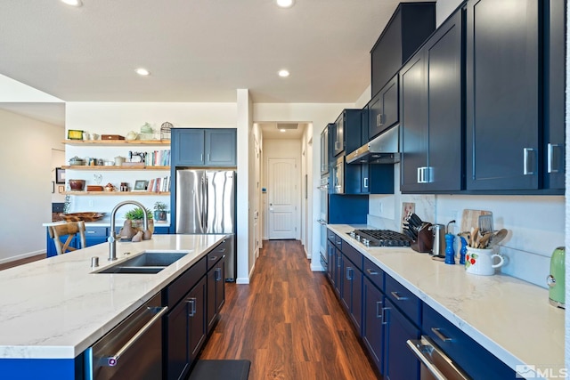 kitchen with dark wood-type flooring, sink, blue cabinetry, light stone counters, and stainless steel appliances