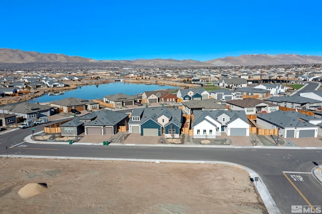 birds eye view of property featuring a water and mountain view