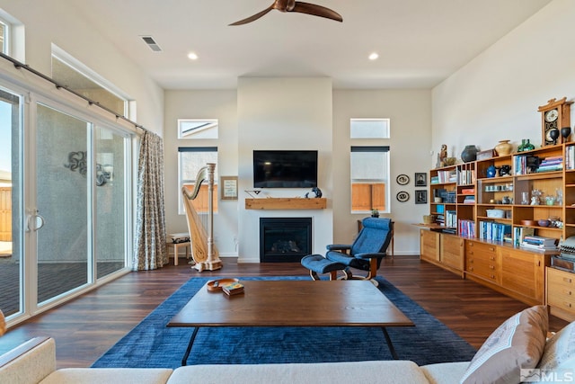 living room with ceiling fan and dark wood-type flooring