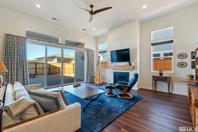 living room featuring dark hardwood / wood-style flooring, ceiling fan, and a healthy amount of sunlight