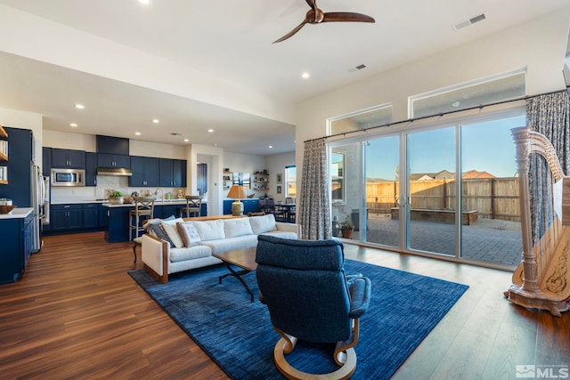 living room with hardwood / wood-style floors, ceiling fan, and sink