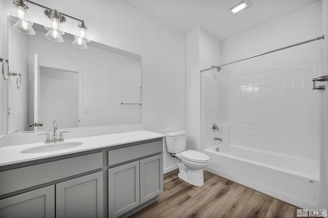 full bathroom with hardwood / wood-style floors, vanity, toilet, and washtub / shower combination