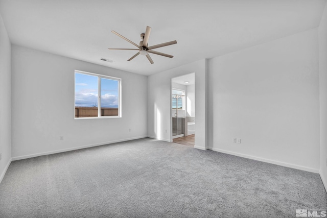 carpeted spare room featuring ceiling fan