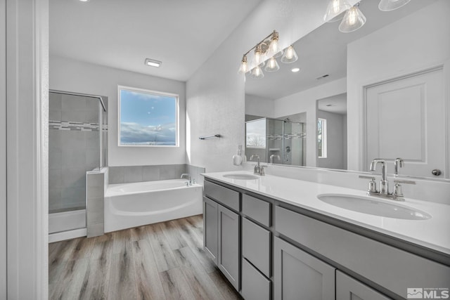 bathroom with shower with separate bathtub, vanity, and wood-type flooring