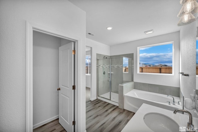 bathroom with sink, independent shower and bath, and hardwood / wood-style flooring