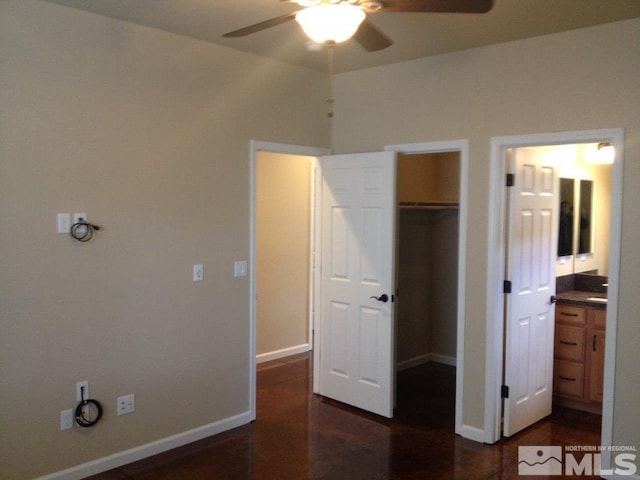 unfurnished bedroom featuring a closet, a spacious closet, ceiling fan, and ensuite bathroom