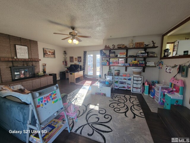 living room with ceiling fan, french doors, and a textured ceiling