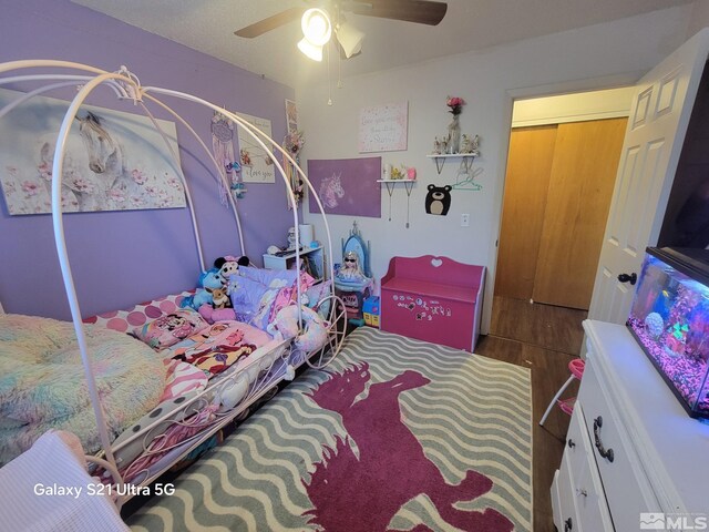 bedroom with ceiling fan, wood-type flooring, and a closet