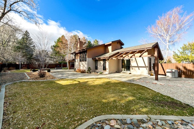 rear view of house with a yard, a patio, and central AC unit