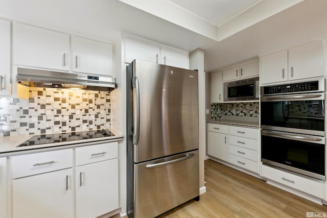 kitchen featuring decorative backsplash, white cabinetry, appliances with stainless steel finishes, and light hardwood / wood-style flooring