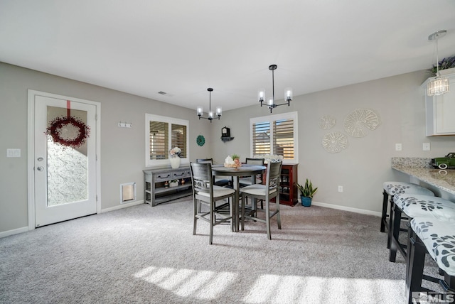 carpeted dining space with a notable chandelier