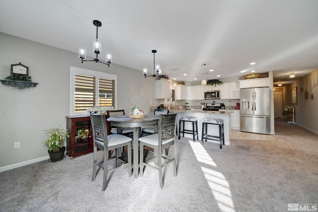 dining room with a notable chandelier, light colored carpet, and sink