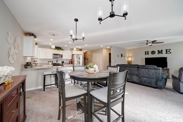 dining area featuring light colored carpet, ceiling fan, and sink