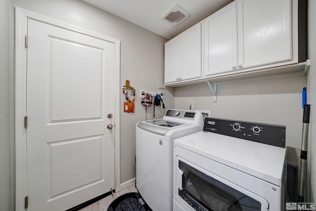 laundry area featuring washer and clothes dryer and cabinets