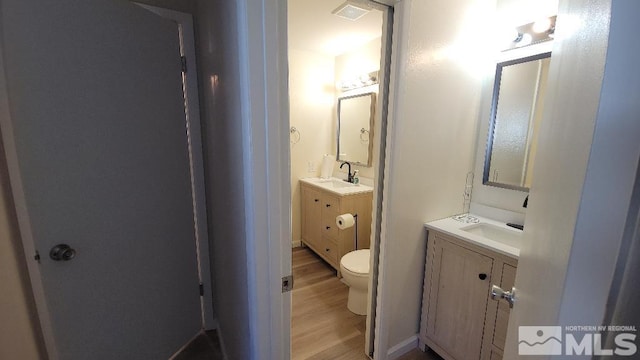 bathroom with toilet, vanity, and hardwood / wood-style flooring