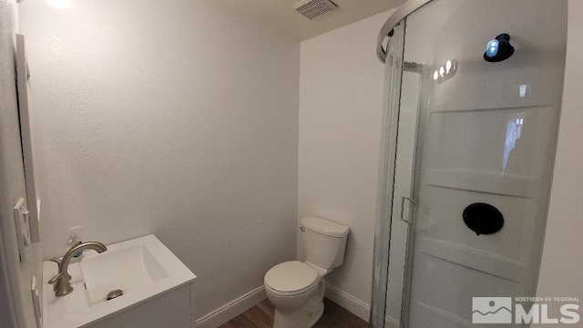 bathroom featuring a shower with door, wood-type flooring, and toilet