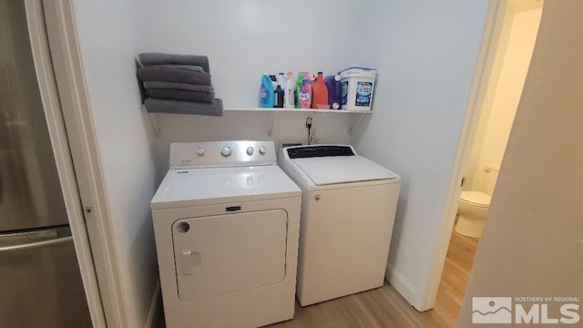 laundry area featuring light wood-type flooring and washer and clothes dryer