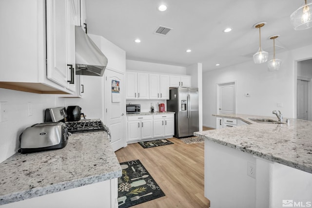 kitchen featuring white cabinetry, sink, stainless steel appliances, range hood, and pendant lighting