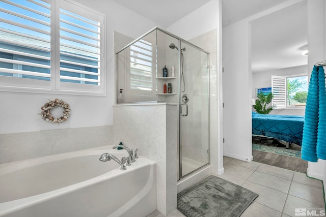 bathroom with separate shower and tub and tile patterned floors