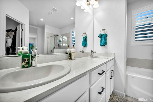 bathroom featuring vanity, a healthy amount of sunlight, and shower with separate bathtub