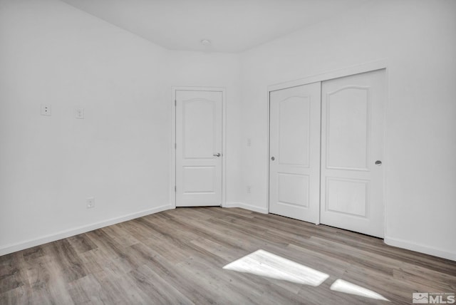 unfurnished bedroom featuring a closet and light wood-type flooring