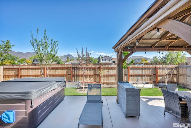 view of patio / terrace featuring a gazebo, a mountain view, and a hot tub