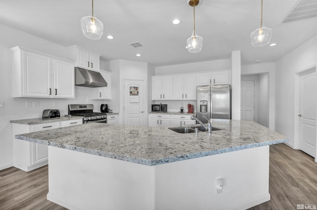 kitchen featuring appliances with stainless steel finishes, a spacious island, sink, decorative light fixtures, and white cabinetry