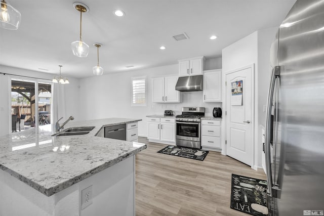 kitchen featuring stainless steel appliances, a spacious island, sink, pendant lighting, and white cabinets